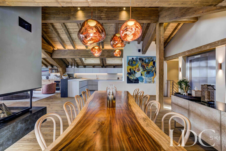 Long wooden dining table beneath statement lighting at Chalet Constantia