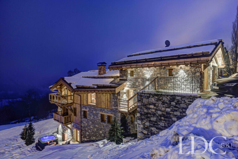 Stone exterior of Chalet Constantia illuminated against the evening sky