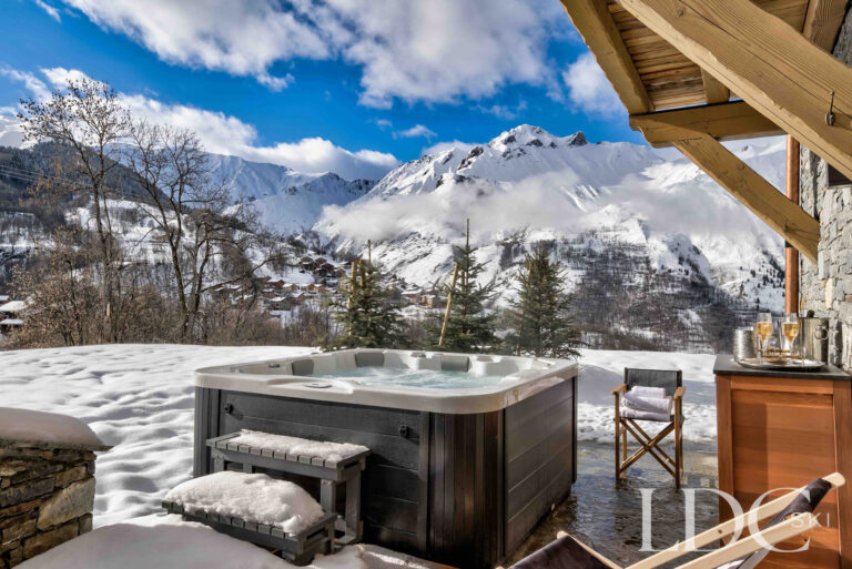 Outdoor hot tub overlooking the snow-covered mountains at Chalet Constantia