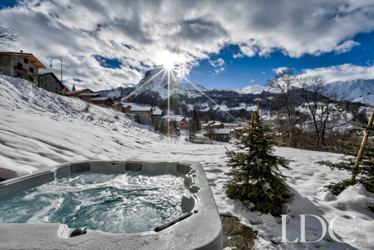 Panoramic snowy mountain view from the outdoor hot tub at Chalet Constantia