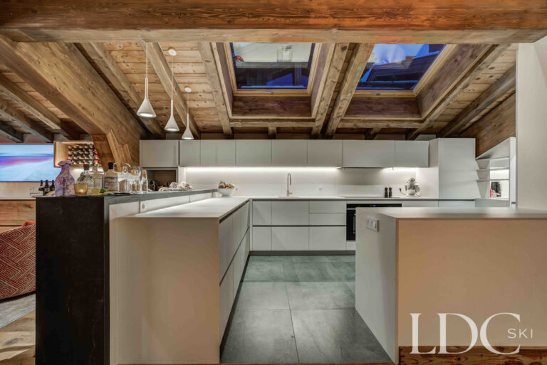 Contemporary kitchen beneath the chalet's original timber roof structure