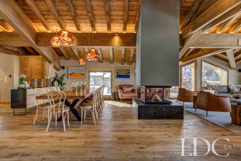 Open-plan living and dining area with fireplace and exposed timber beams at Chalet Constantia