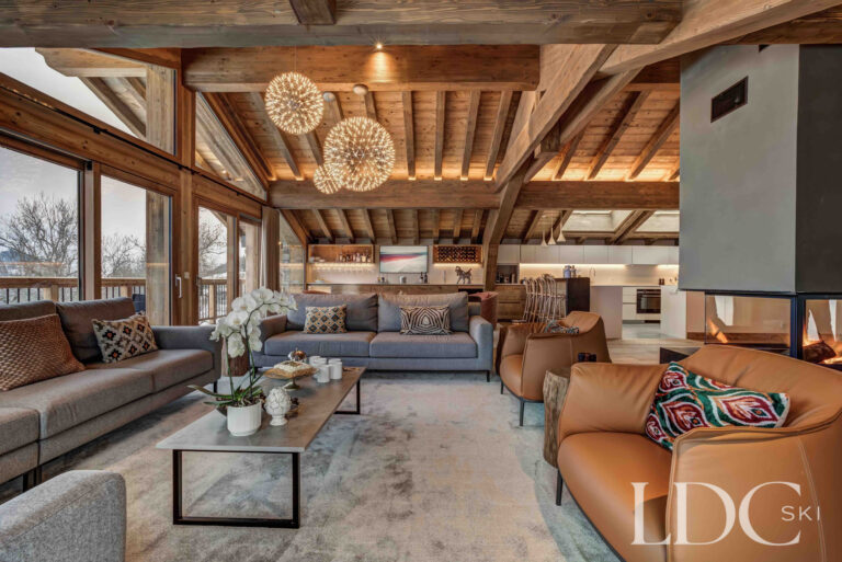 Generous open-plan lounge with sofas, exposed beams and mountain views at Chalet Constantia
