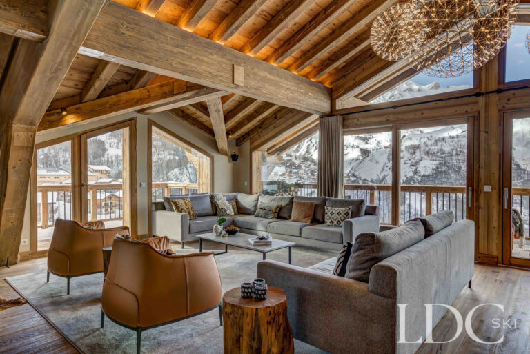 Chalet Constantia's lounge with floor-to-ceiling windows overlooking the snowy mountains