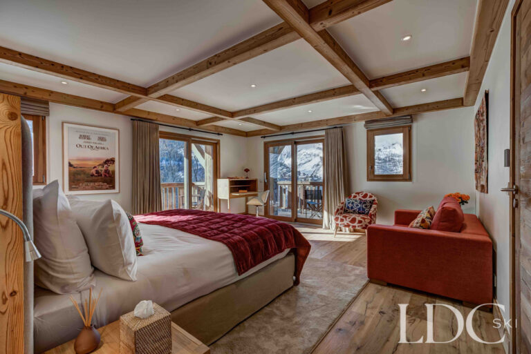 Master bedroom with large windows overlooking the snowy mountains at Chalet Constantia