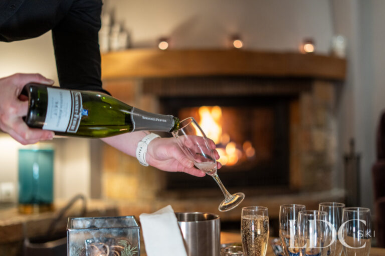 Champagne being served beside the log fire at Chalet Pasarale in Méribel