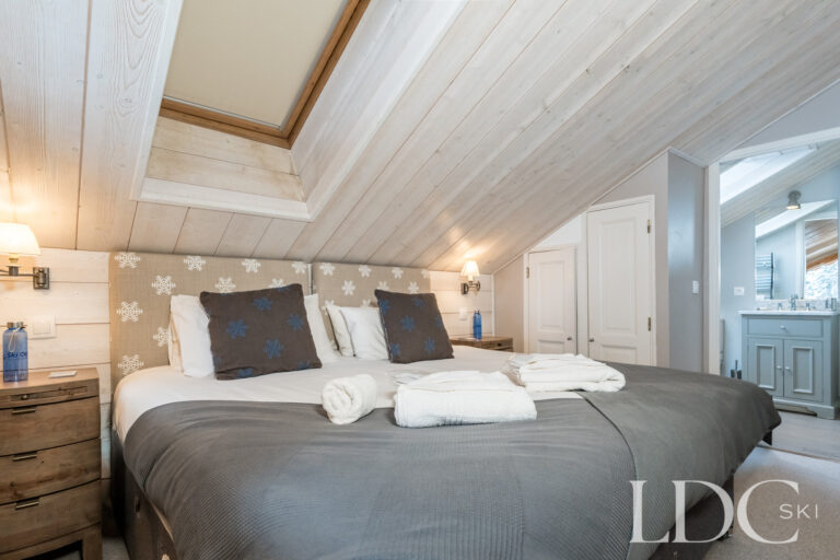Double bedroom beneath a timber vaulted ceiling at Chalet Pasarale