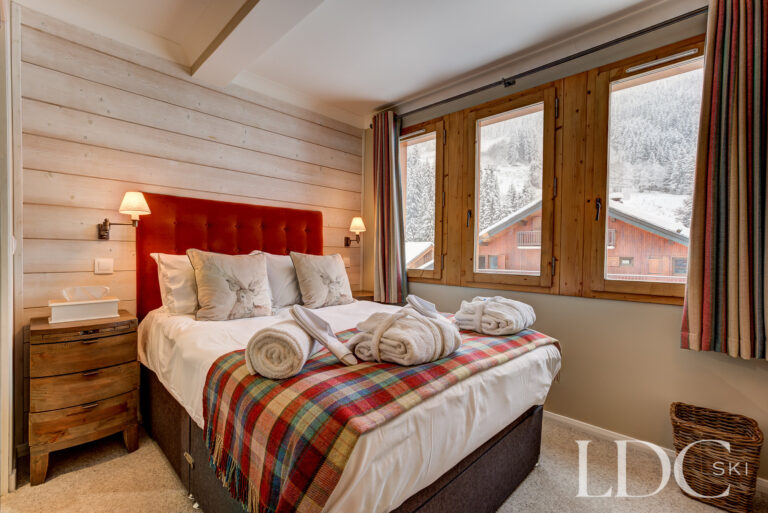 Double bedroom with warm timber detailing at Chalet Pasarale