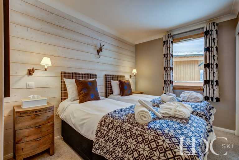 Twin bedroom with Alpine-style furnishings at Chalet Pasarale in Méribel