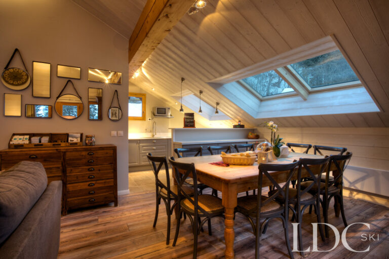 Cosy dining area beneath the sloping timber ceiling at Chalet Pasarale