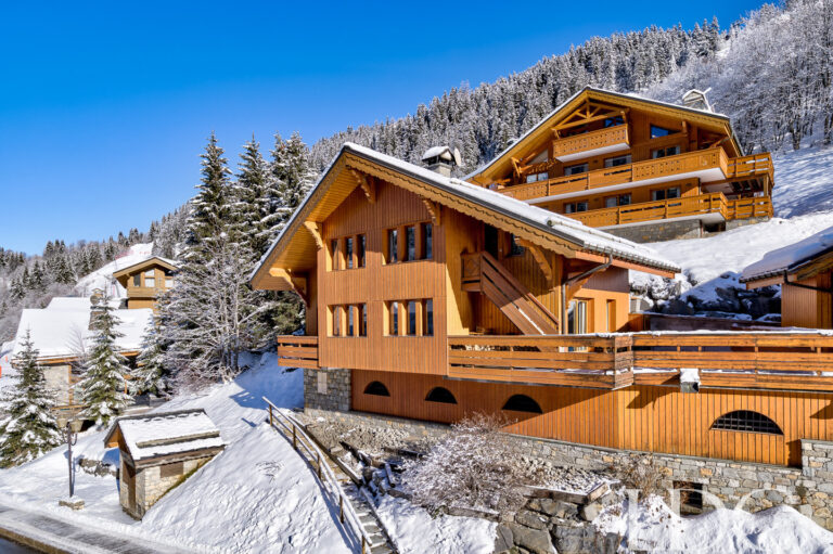 Snow-covered exterior of Chalet Pasarale in Méribel
