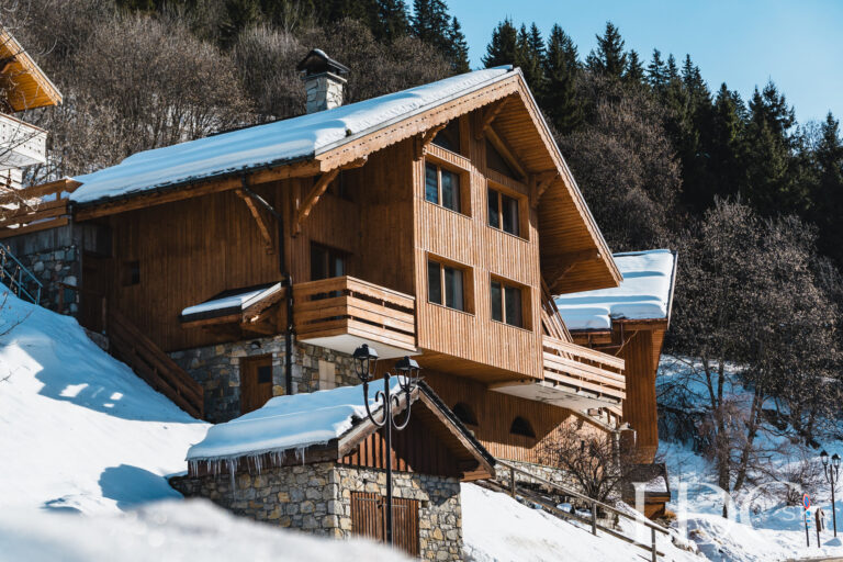 Traditional timber exterior of Chalet Pasarale surrounded by snow in Méribel