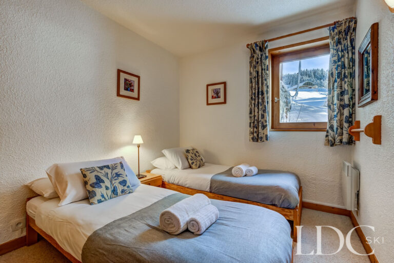 Twin bedroom with snowy mountain views at Chalet Veronica
