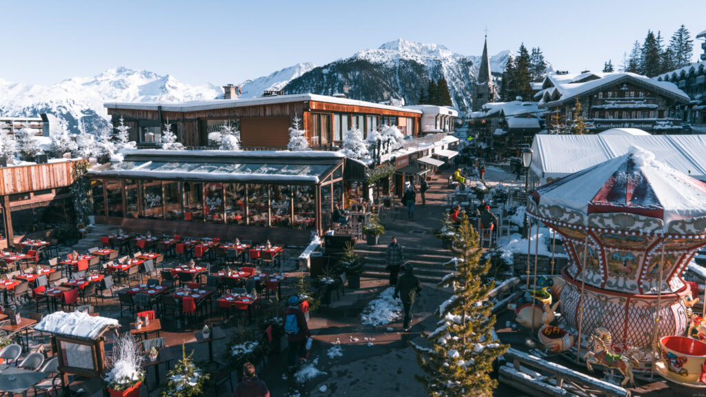 Snow-covered buildings and mountain scenery in Courchevel 1850. © Un Duo.