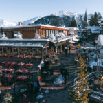 Snow-covered buildings and mountain scenery in Courchevel 1850. © Un Duo.
