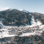 Aerial winter view of Courchevel Le Praz surrounded by forest and snowy slopes. © Un Duo.