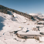 Winter view of Courchevel Le Praz surrounded by forest and snow-covered mountains. © Un Duo.