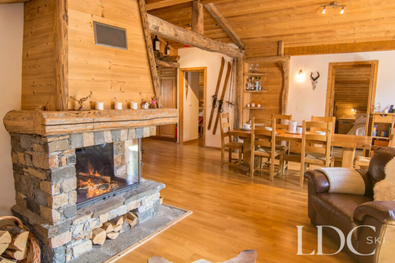Open-plan living and dining area with stone fireplace at Encombres Tête de Fer