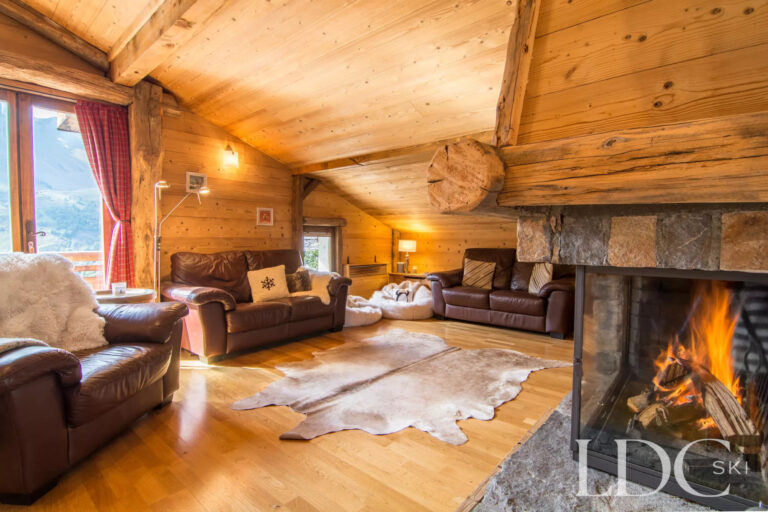 Spacious Alpine lounge at Encombres Tête de Fer with leather sofas and a stone fireplace
