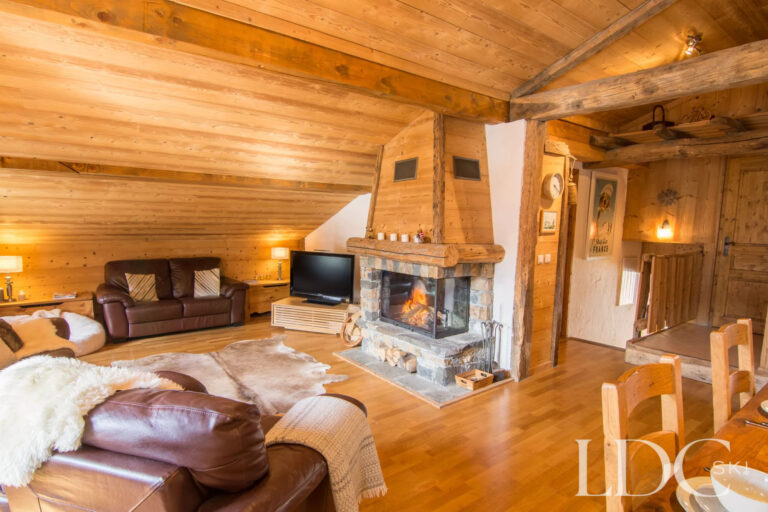Traditional Alpine lounge with leather seating and stone fireplace at Encombres Tête de Fer