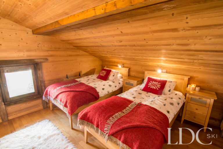 Twin bedroom with exposed timber and Alpine-style furnishings at Encombres Tête de Fer