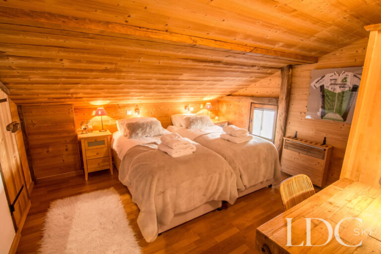 Cosy twin bedroom beneath a timber ceiling at Encombres Tête de Fer