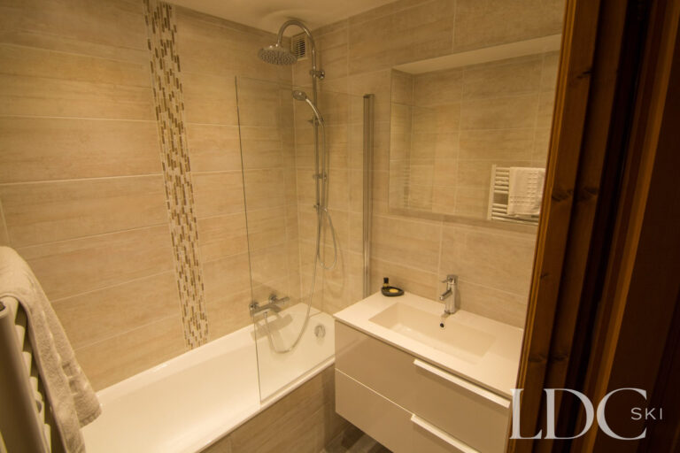 Bathroom with bath and overhead shower at Iris in St Martin de Belleville