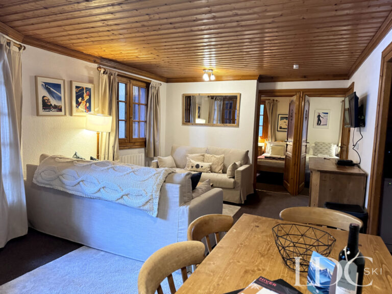 Open-plan lounge and dining area with traditional timber ceiling at Iris in St Martin de Belleville