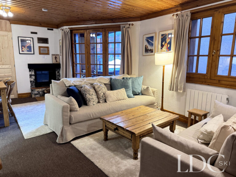 Comfortable lounge with fireplace and windows overlooking St Martin de Belleville