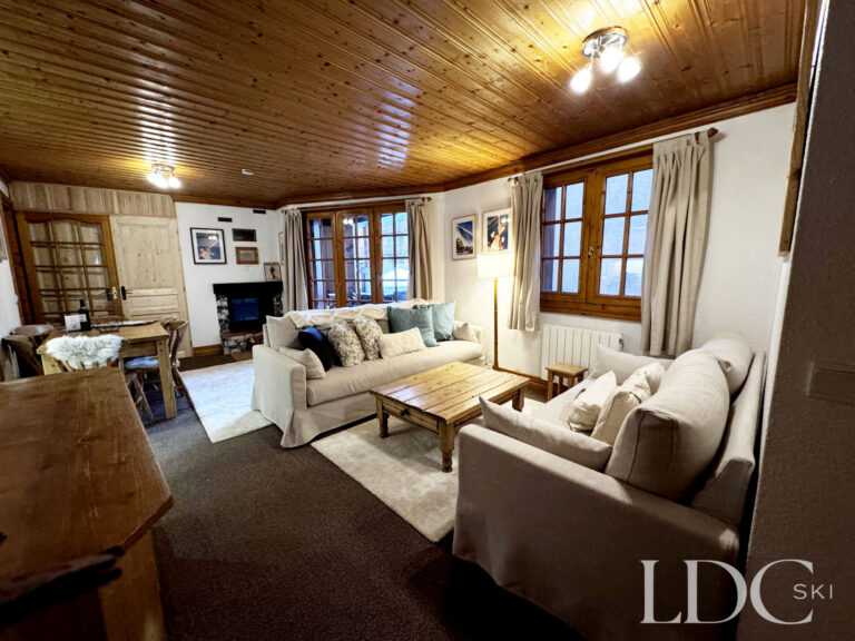 Comfortable lounge with fireplace and traditional timber ceiling at Iris in St Martin de Belleville
