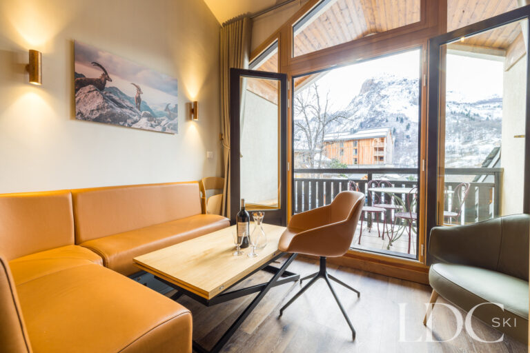 Contemporary lounge with balcony doors and mountain views at La Florette