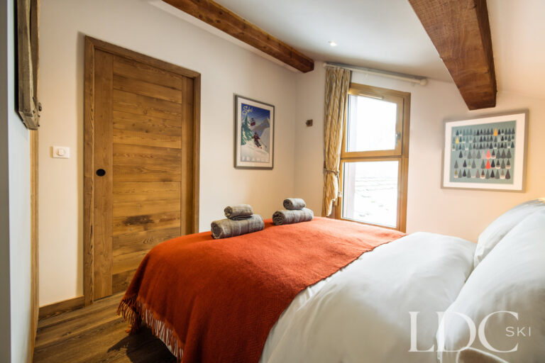 Master bedroom with warm timber detailing and roof window at La Florette