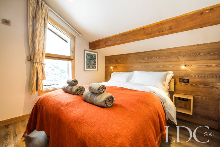 Master bedroom with exposed timber beams at La Florette in St Martin de Belleville