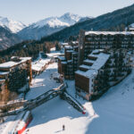 Aerial winter view of La Tania village surrounded by forest and ski slopes. © Un Duo.
