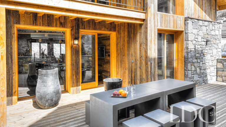 Sunny timber balcony and outdoor seating area at Le Chalet