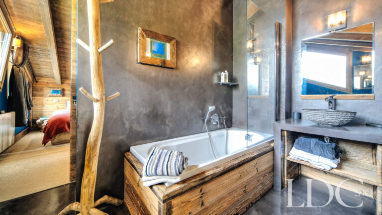 Bathroom with wooden bath and contemporary fittings at Le Chalet