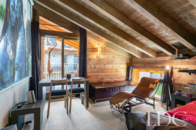 Relaxed cinema seating area with timber ceiling at Le Chalet