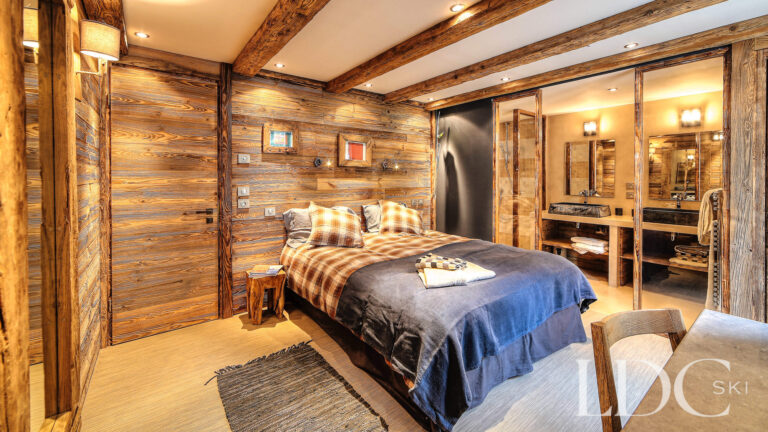 Double bedroom with traditional timber features and balcony access at Le Chalet