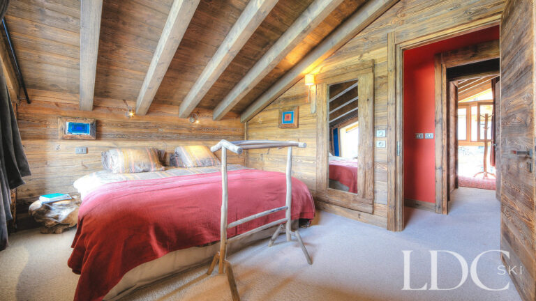 Twin bedroom with exposed beams and traditional Alpine character at Le Chalet