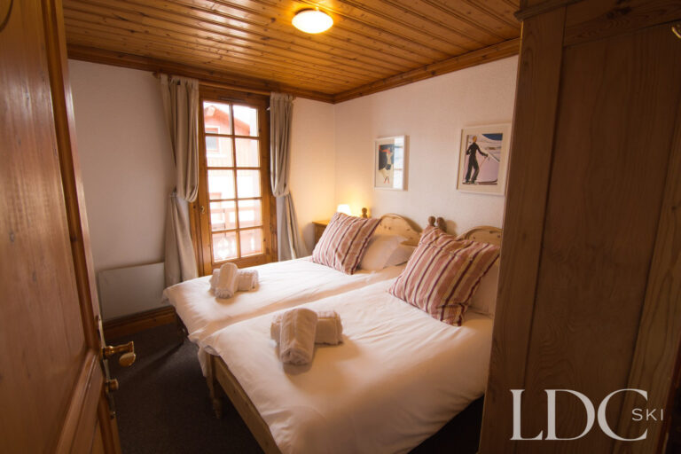 Twin bedroom with traditional wooden detailing at Marguerite