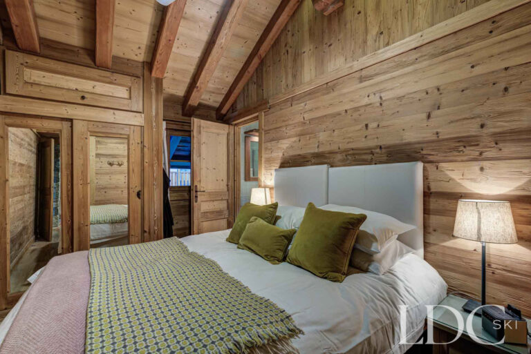 Double bedroom with rustic timber walls at Nant Giraud