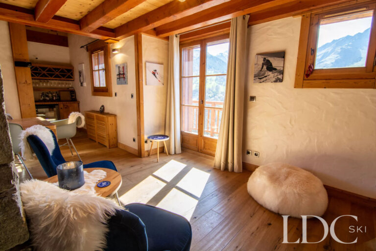 Bright lounge at Nant Giraud opening onto the balcony with mountain views in St Martin de Belleville