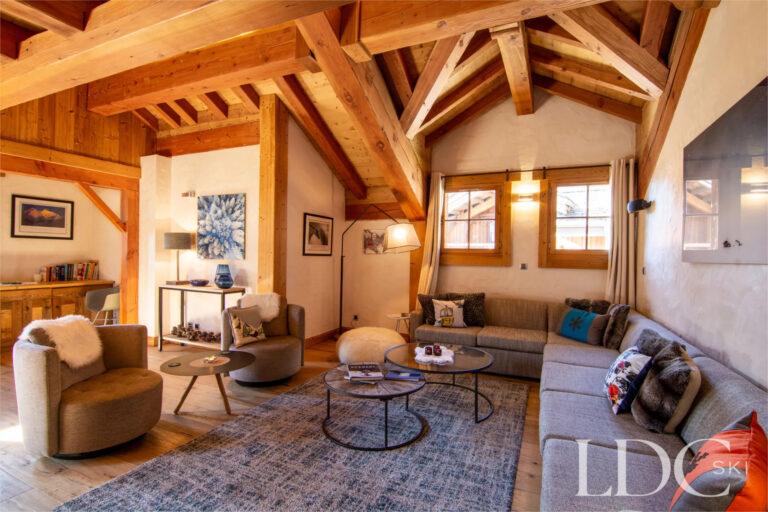 Spacious Alpine lounge with exposed timber beams at Nant Giraud