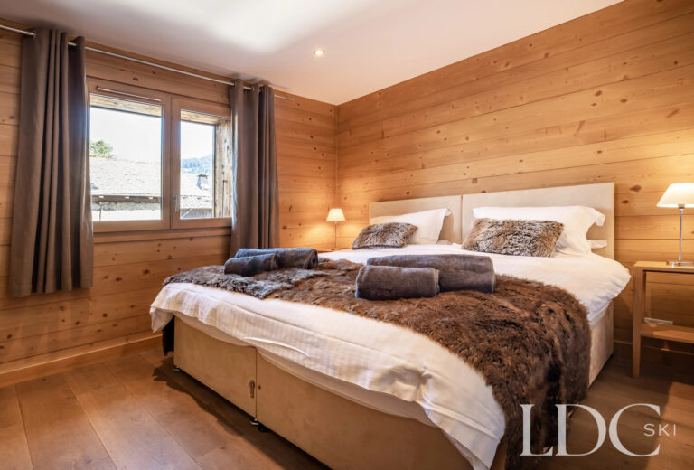 Double bedroom with timber walls at Petit Sapin in Morzine