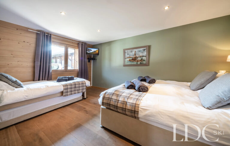 Family bedroom with double bed and additional guest bed at Petit Sapin