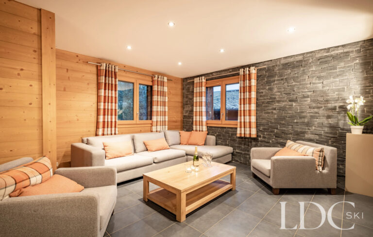 Lounge with sofas and natural stone feature wall at Petit Sapin