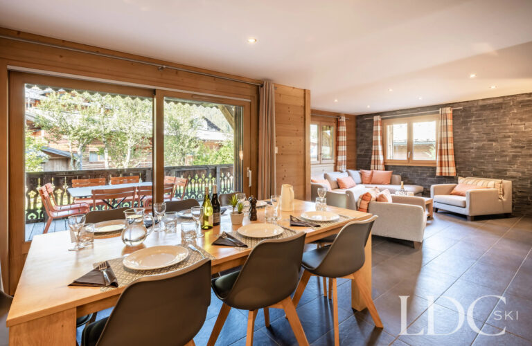 Open plan living and dining area opening onto the balcony at Petit Sapin in Morzine
