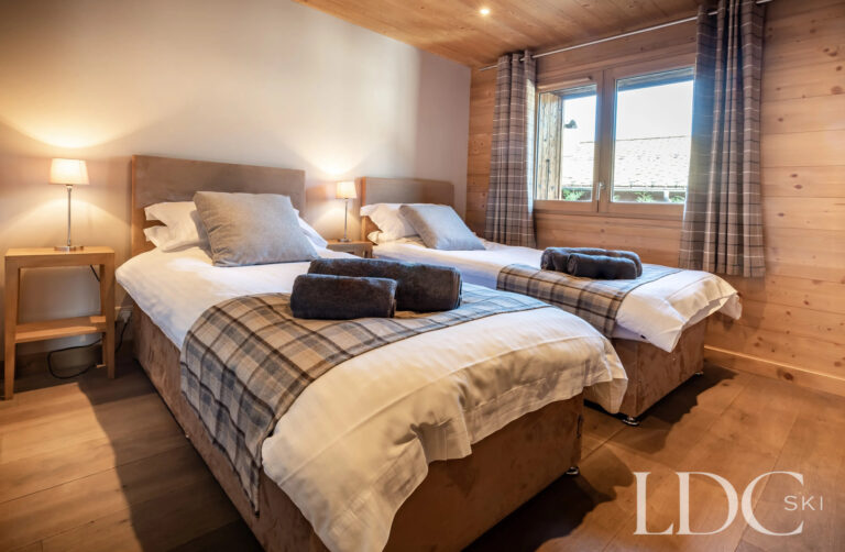 Twin bedroom with timber walls at Petit Sapin in Morzine