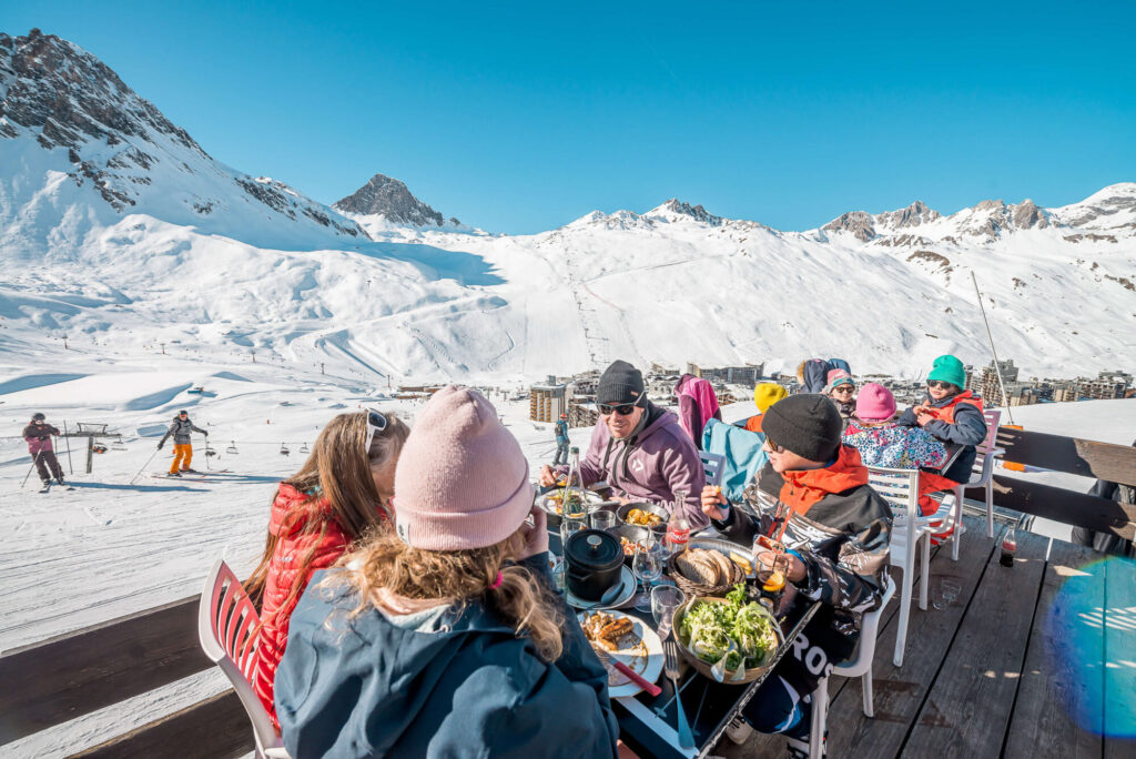 Skiers enjoying a sunny mountain restaurant terrace in Tignes. © Andy Parant