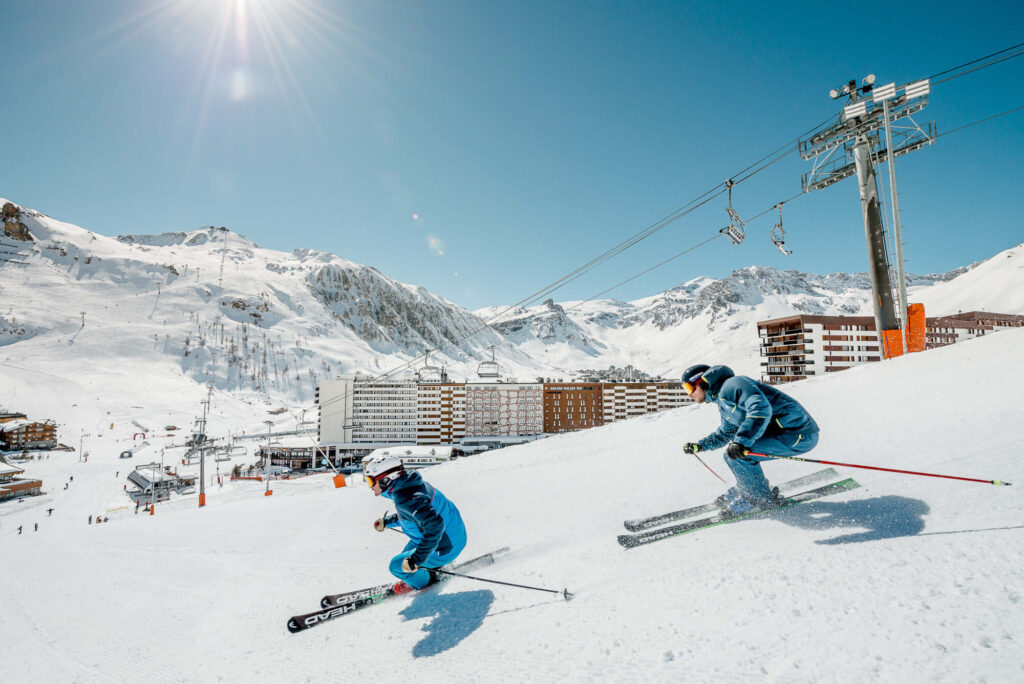 Skiers descending beneath a chairlift on the slopes of Tignes. © Andy Parant